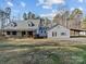 Back of the home, featuring a metal roof, a large building with a garage, and natural surroundings at 265 River Run Rd, Statesville, NC 28625