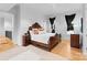 A spacious bedroom featuring a decorative bed frame, dark curtains, and hardwood floors at 2818 Kenwood Sharon Ln, Charlotte, NC 28211