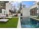 Serene backyard with a modern pool, fireplace, lounge chairs, and lush greenery, perfect for relaxation at 2818 Kenwood Sharon Ln, Charlotte, NC 28211