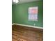 Bedroom featuring green walls, a window, and hardwood flooring at 2921 Fort St, Charlotte, NC 28205