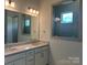 Bathroom featuring double sinks, framed mirrors, and sleek tile shower with glass surround at 305 Basil Dr, Indian Trail, NC 28079