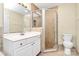 Bathroom with a glass-enclosed shower, white vanity, and neutral tile at 3200 Highview Rd, Charlotte, NC 28210