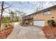 Rear view of a brick house with a deck, lower level garage, and long, private driveway at 3200 Highview Rd, Charlotte, NC 28210
