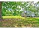 Lush backyard showcasing a charming two-story home with a wooden staircase and well-maintained lawn at 3640 Oak Haven Ln, Shelby, NC 28150
