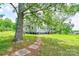 Spacious backyard with a stone path leading to a charming two-story home with wooden staircase at 3640 Oak Haven Ln, Shelby, NC 28150