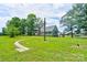 Large backyard featuring lush lawn, stone pathway, and a charming home with a brick chimney at 3640 Oak Haven Ln, Shelby, NC 28150