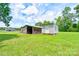 View of two outbuildings, including a barn and shed, in a lush green yard on a sunny day at 3640 Oak Haven Ln, Shelby, NC 28150