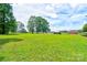 Large green lawn featuring a house, barn, shed and solar panels under a beautiful sky at 3640 Oak Haven Ln, Shelby, NC 28150