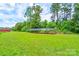 Wide view of lush yard with solar panel system and outbuildings, under a sunny sky at 3640 Oak Haven Ln, Shelby, NC 28150