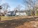 Exterior back view of a home with a large grassy yard, offering a peaceful and private outdoor space at 3711 Davis Dr, Charlotte, NC 28270