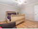 A cozy bedroom with hardwood floors, a ceiling fan, and a comfortable-looking bed with purple pillows at 3711 Davis Dr, Charlotte, NC 28270