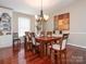 Beautiful dining area featuring wood flooring, a chandelier, built-in bookcases, and a neutral palette at 3711 Davis Dr, Charlotte, NC 28270