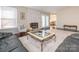 Cozy living space featuring a stone fireplace, hardwood floors, and a view into the kitchen at 3711 Davis Dr, Charlotte, NC 28270