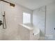 Walk-in shower with corner tub features elegant marble-style tile and a rain shower head at 433 Annaberg Ln, Monroe, NC 28110
