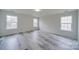 A light-filled bedroom with three bright windows and durable, light gray wood floors at 433 Annaberg Ln, Monroe, NC 28110