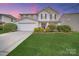 Charming two-story home featuring a well-manicured lawn, beautiful landscaping, and a classic design with a red front door at 433 Annaberg Ln, Monroe, NC 28110