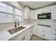 Bright kitchen features white cabinets, quartz countertops, a stainless sink, and subway tile backsplash at 433 Annaberg Ln, Monroe, NC 28110