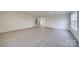 Spacious living room with neutral walls, light gray floors, and ample natural light, creating a bright and airy atmosphere at 433 Annaberg Ln, Monroe, NC 28110