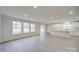 Open-concept living area with abundant natural light, white walls, light gray floors, and a modern kitchen in the background at 433 Annaberg Ln, Monroe, NC 28110