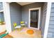 Cozy front porch featuring a bright rug, 2 yellow chairs, and a black door at 508 Tayberry Ln, Fort Mill, SC 29715