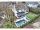 Aerial view of a beautiful home with a pool, putting green, screened-in porch, and manicured lawn at 5231 Lila Wood Cir, Charlotte, NC 28209