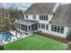 An elevated view showcases the backyard pool, putting green, patio, screened-in porch, and lush lawn at 5231 Lila Wood Cir, Charlotte, NC 28209
