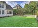 A manicured lawn and putting green, surrounded by lush landscaping, enhance the backyard appeal at 5231 Lila Wood Cir, Charlotte, NC 28209