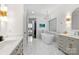 Bright bathroom with marble floors, soaking tub, double vanity, modern fixtures, and separate walk-in closet at 5231 Lila Wood Cir, Charlotte, NC 28209