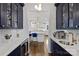 Stylish kitchen featuring navy blue cabinets, marble countertops, and modern appliances at 5231 Lila Wood Cir, Charlotte, NC 28209