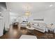 Open-concept living space with hardwood floors, fireplace, modern decor, and a view into the bright kitchen at 5231 Lila Wood Cir, Charlotte, NC 28209