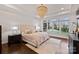 Comfortable main bedroom with lots of natural light, hardwood floors, and tray ceiling with a chandelier at 5231 Lila Wood Cir, Charlotte, NC 28209