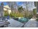 Backyard pool area with stone tiling, lounge furniture, and lush landscaping surrounding it at 5231 Lila Wood Cir, Charlotte, NC 28209