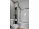 A bathroom with a toilet and shower-tub combo, along with shelves for storage at 56 Linneys Mountain Rd, Taylorsville, NC 28681