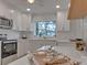 White kitchen with stainless steel microwave and stove, and an inviting breakfast bar at 56 Linneys Mountain Rd, Taylorsville, NC 28681