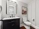 Stylish powder room featuring a dark vanity, marble countertop, and decorative mirror at 618 Bannerman Ln, Fort Mill, SC 29715