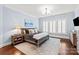 Comfortable bedroom with soft blue walls, hardwood floors, and plantation shutters at 618 Bannerman Ln, Fort Mill, SC 29715