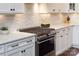 Gourmet kitchen features stainless steel range, white subway tile backsplash, and ample counter space at 618 Bannerman Ln, Fort Mill, SC 29715