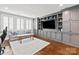 Cozy living room featuring gray walls, custom shelving, and plantation shutters at 618 Bannerman Ln, Fort Mill, SC 29715