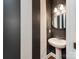 Stylish powder room with modern fixtures, pedestal sink, and black and white striped accent wall at 6332 Kennard Dr, Charlotte, NC 28216