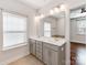 Well-lit bathroom with a double vanity, large mirror, and a window for natural light, connecting to a bedroom at 6332 Kennard Dr, Charlotte, NC 28216