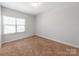 A well-lit bedroom with plush carpeting, a bright window, and neutral walls at 6332 Kennard Dr, Charlotte, NC 28216