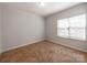 A serene bedroom with plush carpeting, a large window, and neutral walls at 6332 Kennard Dr, Charlotte, NC 28216