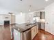 View of the granite island, stainless fridge, and open-concept to the living room with fireplace at 6332 Kennard Dr, Charlotte, NC 28216