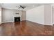 Cozy living room featuring a fireplace, hardwood floors, and a ceiling fan at 6332 Kennard Dr, Charlotte, NC 28216
