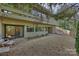 Spacious gravel backyard featuring mature landscaping and modern architecture at 6366 Sharon Hills Rd, Charlotte, NC 28210