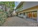A gravel backyard patio area, bordered by modern landscaping, and mature trees at 6366 Sharon Hills Rd, Charlotte, NC 28210
