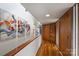 Hallway with bright walls, wooden doors, hardwood floors, and modern artwork at 6366 Sharon Hills Rd, Charlotte, NC 28210