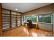 Home office with built-in shelves, large windows, hardwood floors, and a modern desk at 6366 Sharon Hills Rd, Charlotte, NC 28210
