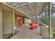 Cozy covered patio with red door, modern furniture and view of surrounding trees at 6366 Sharon Hills Rd, Charlotte, NC 28210