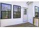 Covered back porch featuring exterior door flanked by black trimmed windows at 66 Reed Ne St, Concord, NC 28025